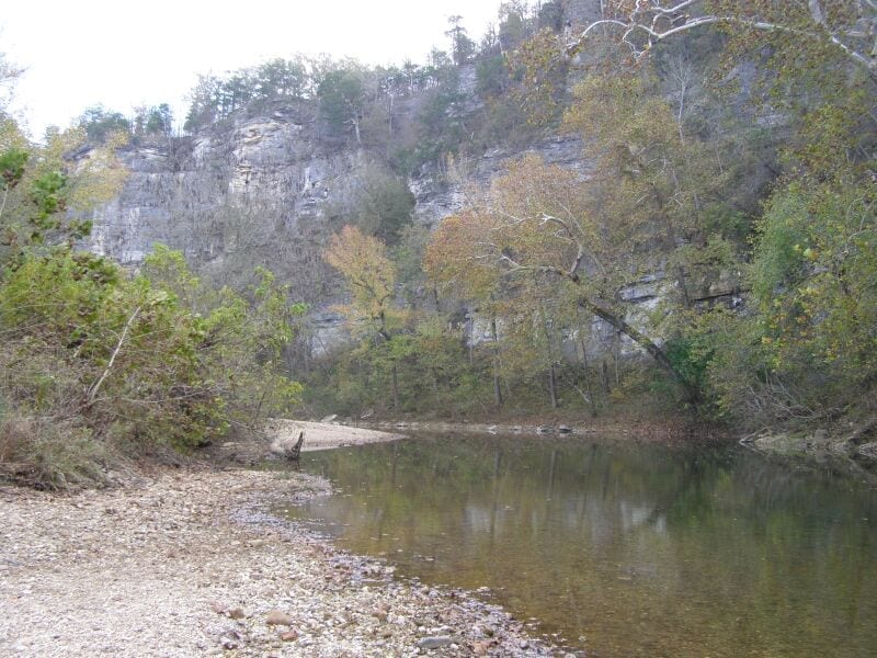 The Buffalo River flows past Pruitt Landing with wooded Ozark hills above the bank in the same corridor used for the Erbie to Hasty continuation.