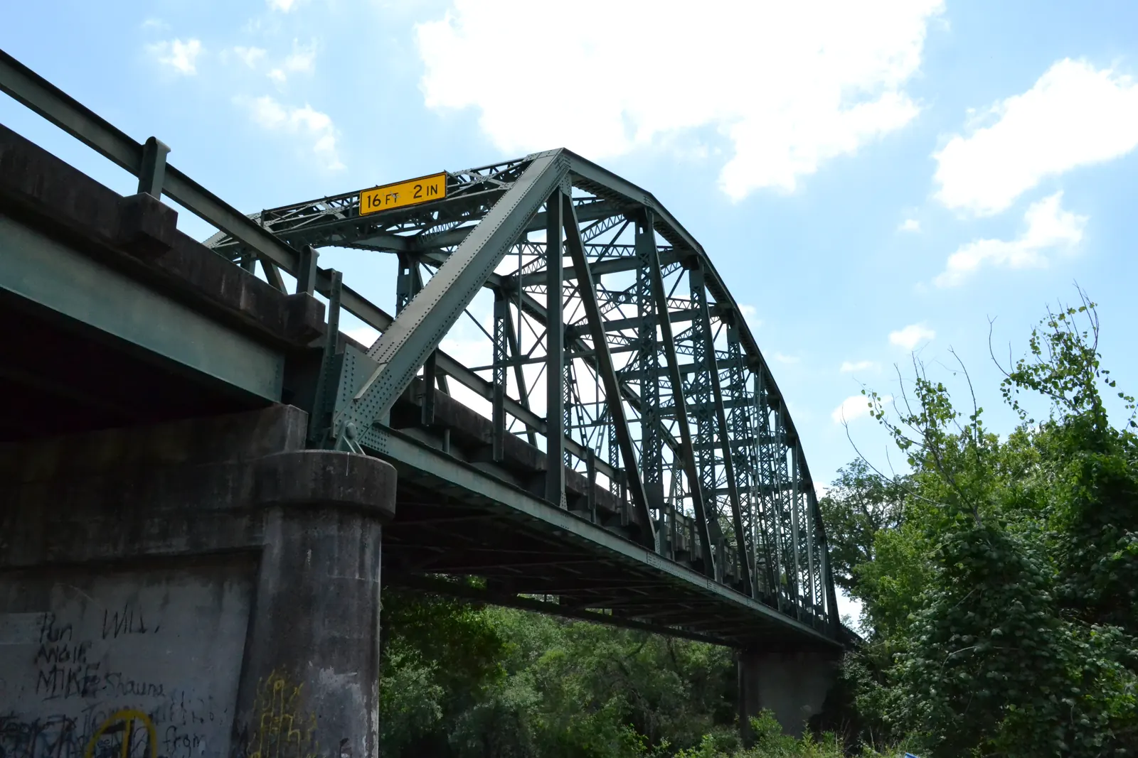 A historic bridge crosses the Guadalupe River southeast of Cuero, Texas, above the broad channel.