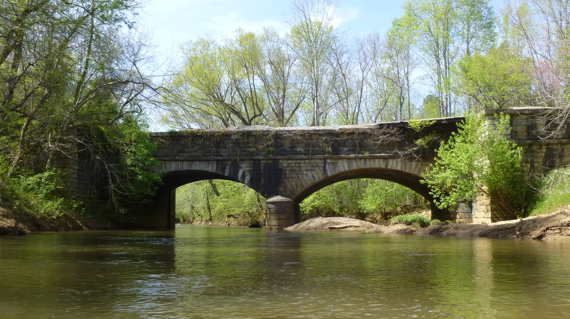 The historic stone Hardware River aqueduct spans the wooded river corridor.