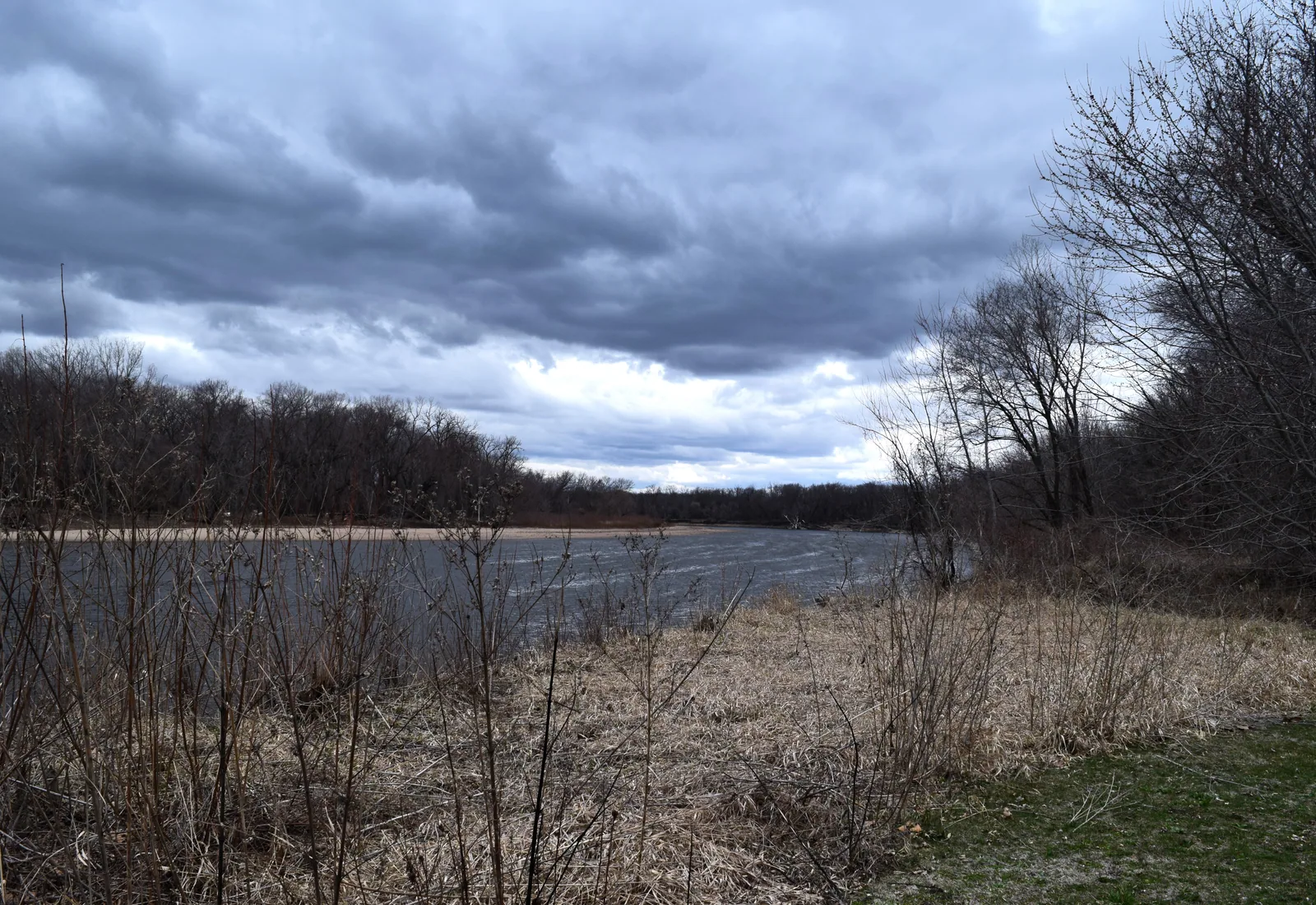 The Cedar River curves past wooded banks beneath a dramatic sky in George Wyth Memorial State Park, Iowa.