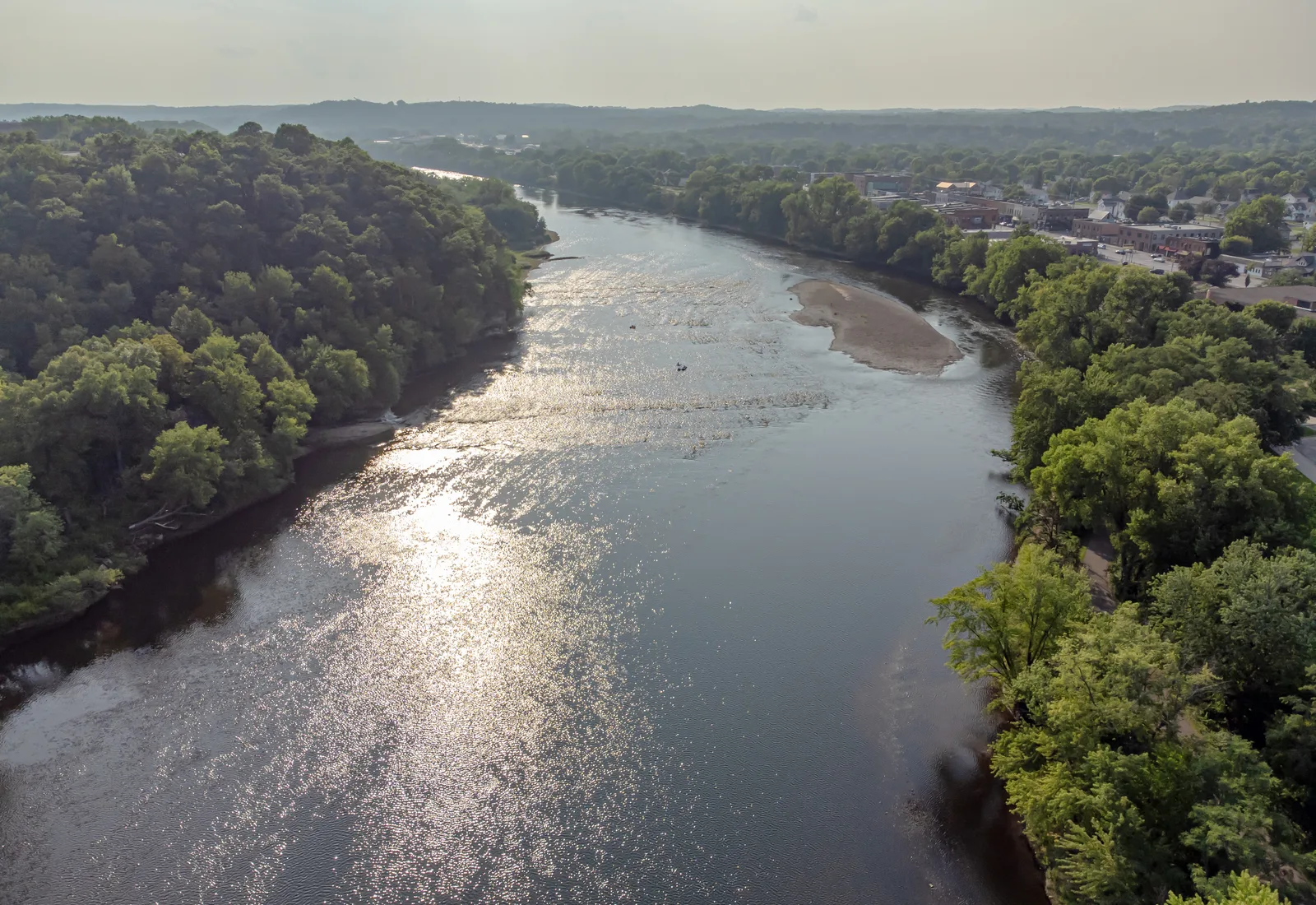 The Chippewa River flows beneath a wooded Wisconsin bluff.