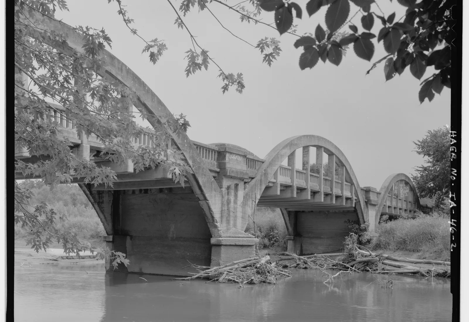 A historic concrete arch bridge spans the North Raccoon River at Lake City, Iowa.