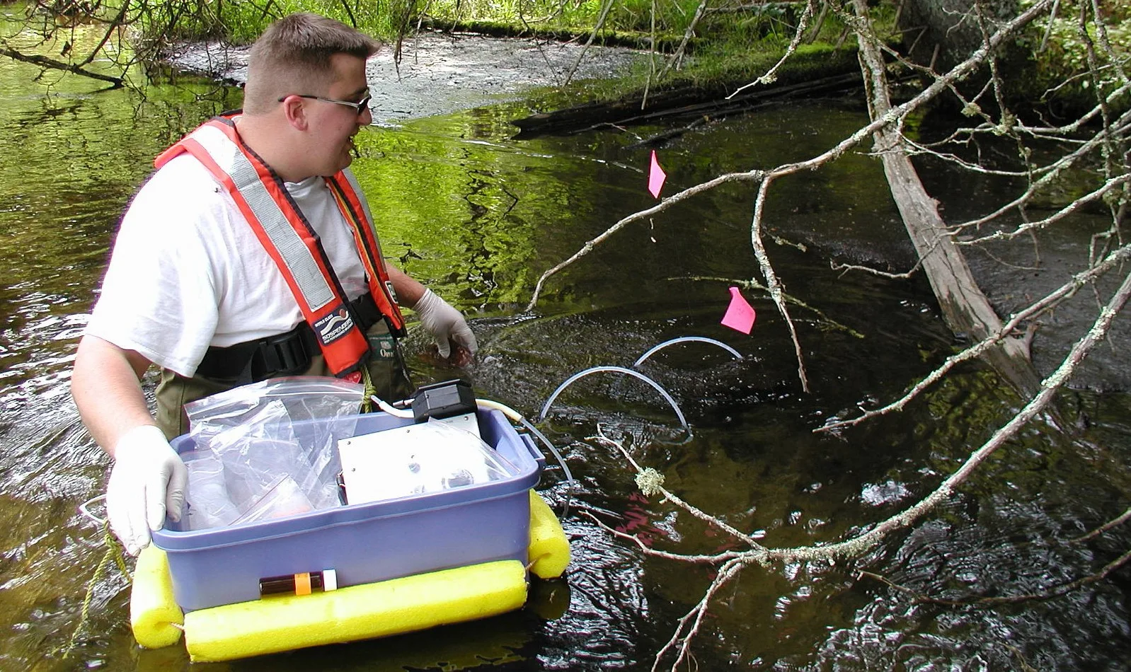 A U.S. Geological Survey scientist collects aquatic species samples from the Pike River in Wisconsin.