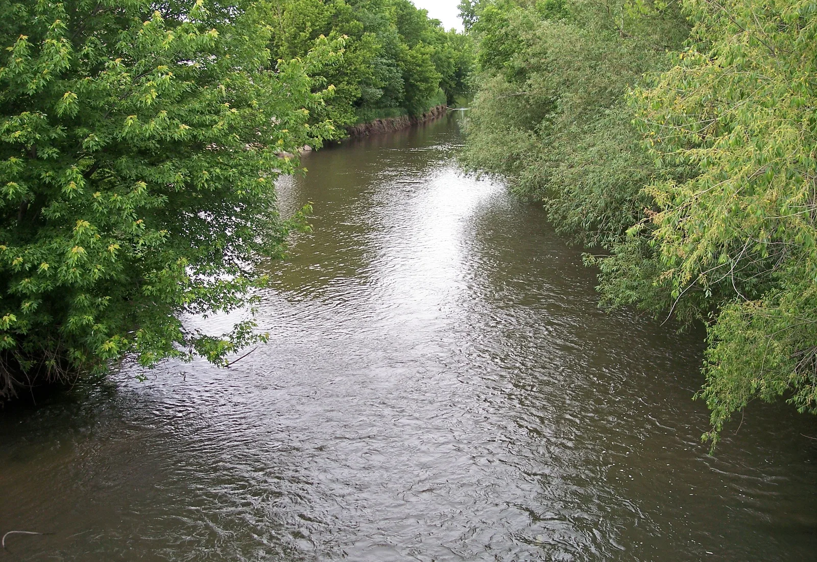 The Straight River flows downstream from Bridge Street in Owatonna, Minnesota.